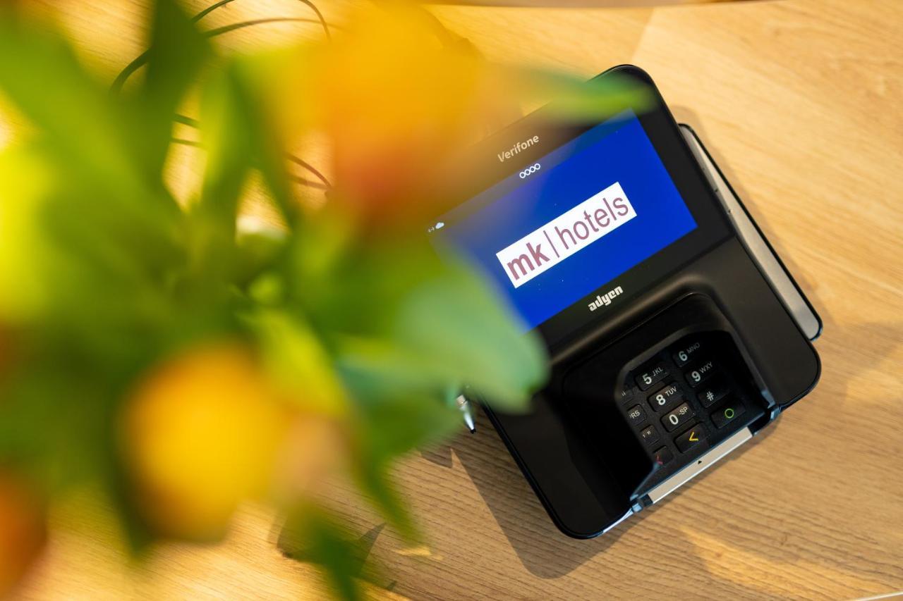 Mk Hotel Tirana Rinas Eksteriør bilde A mobile phone with the MK1Hotels logo on the screen